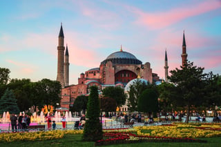 Hagia Sophia al atardecer con movimiento borroso gente caminando y fuente iluminada.  Istanbul, Turquía